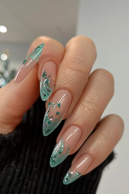 Clear nails with aqua toned tips covered with glitter.