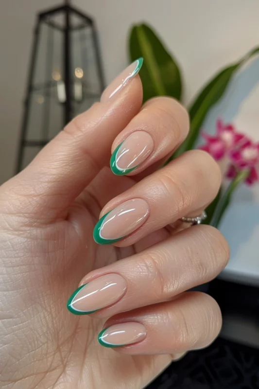 Glossy transparent nails with white and jade green tips.