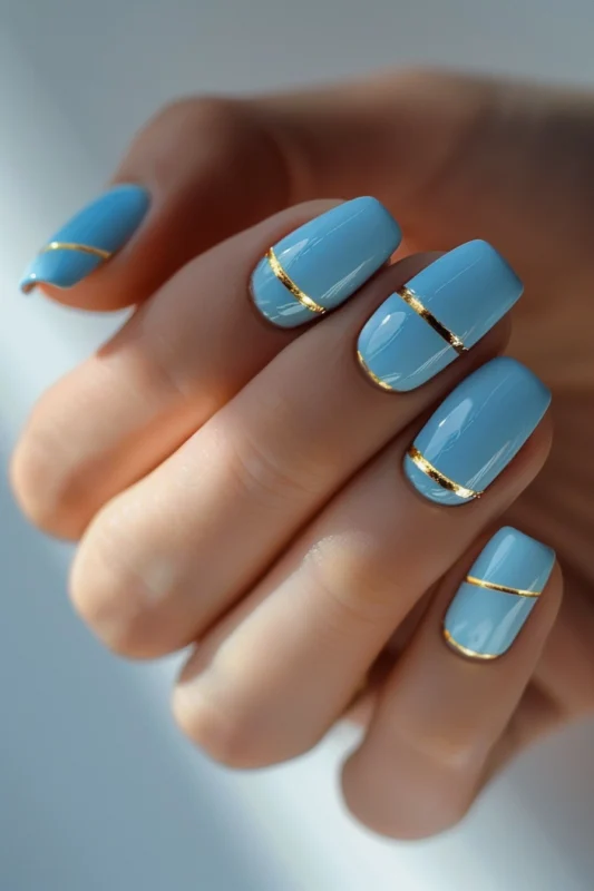 Light blue nails with a delicate gold stripe on each nail.