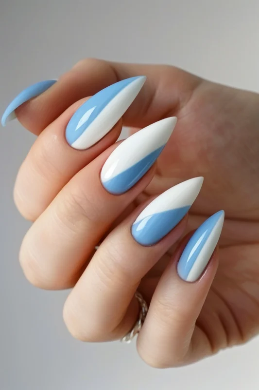 Stiletto nails with a white and light blue gradient.