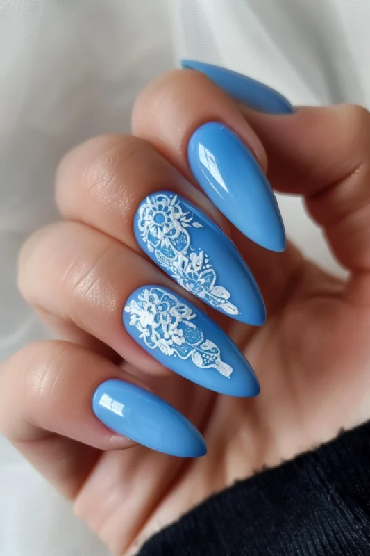 Blue nails with white lace detailing.