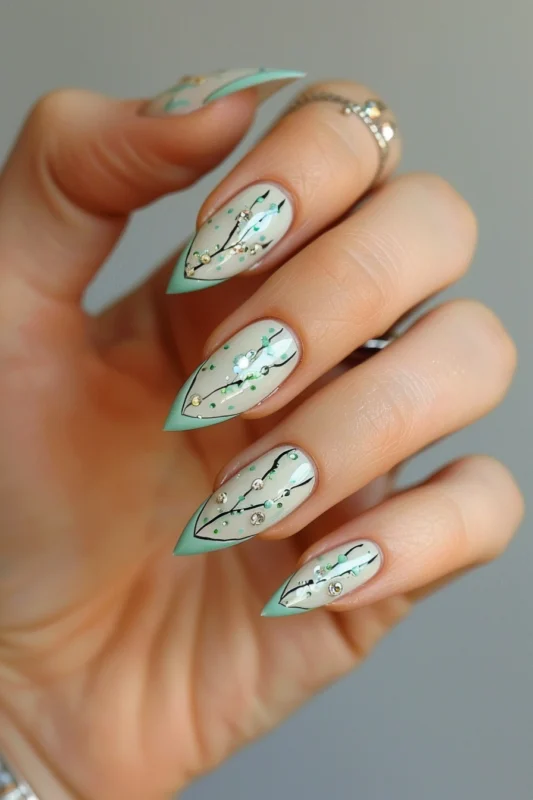 Mint green French tips with back lines and silver embellishments on a creamy base.