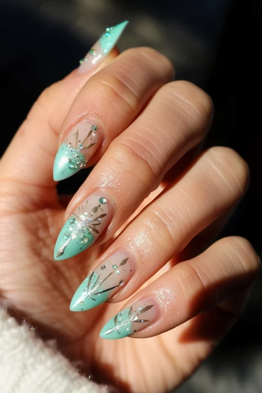 Nails with a minty green French tip and sparkling embellishments.