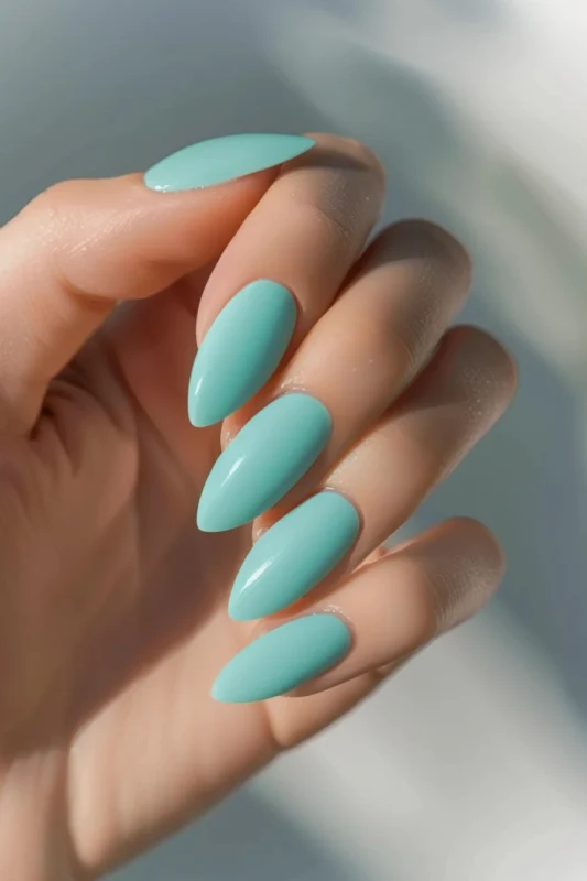 Matte mint green almond-shaped nails.