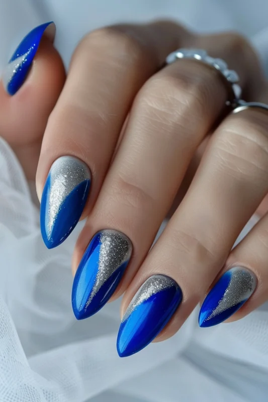 Almond nails with navy blue and sparkling silver tips.