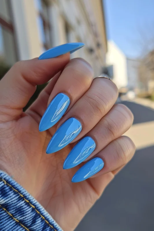 Vibrant neon blue almond-shaped nails.
