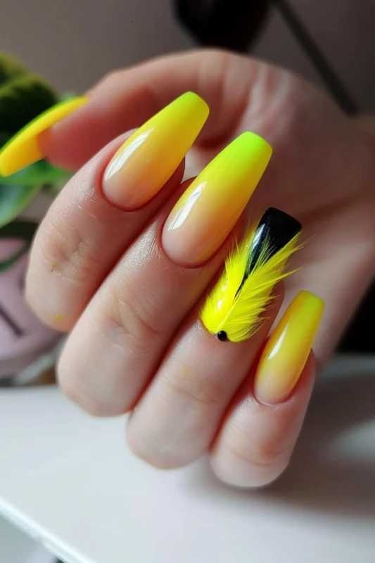 Neon yellow ombre nails with a black accent nail and yellow feather.