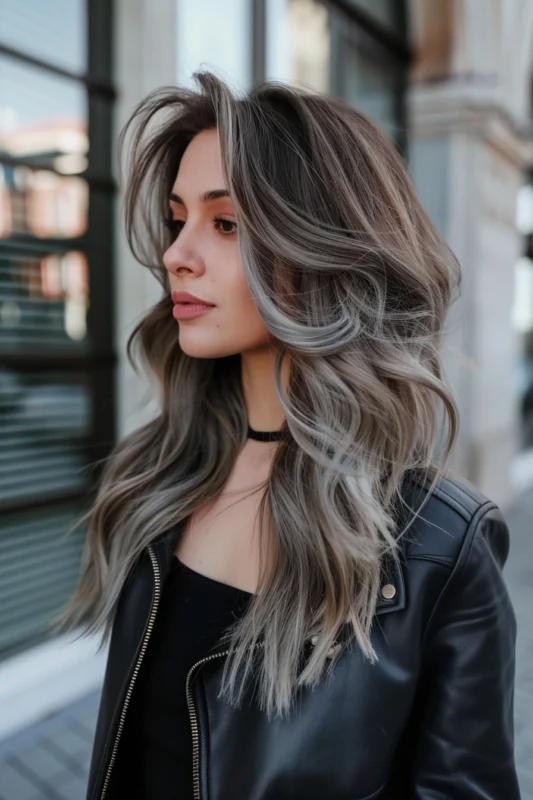Person with a gradient of dark brown to ash blonde to platinum silver hair.