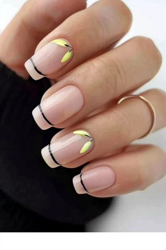 Sheer pink nails with black lines at the tips and delicate yellow leaf designs.