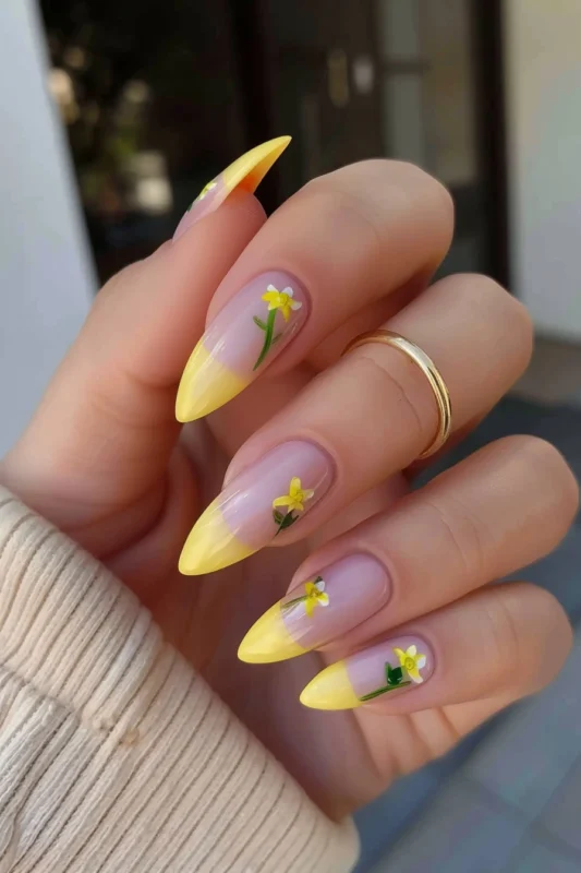 Soft pink nails with pastel yellow tips and flower detailing.
