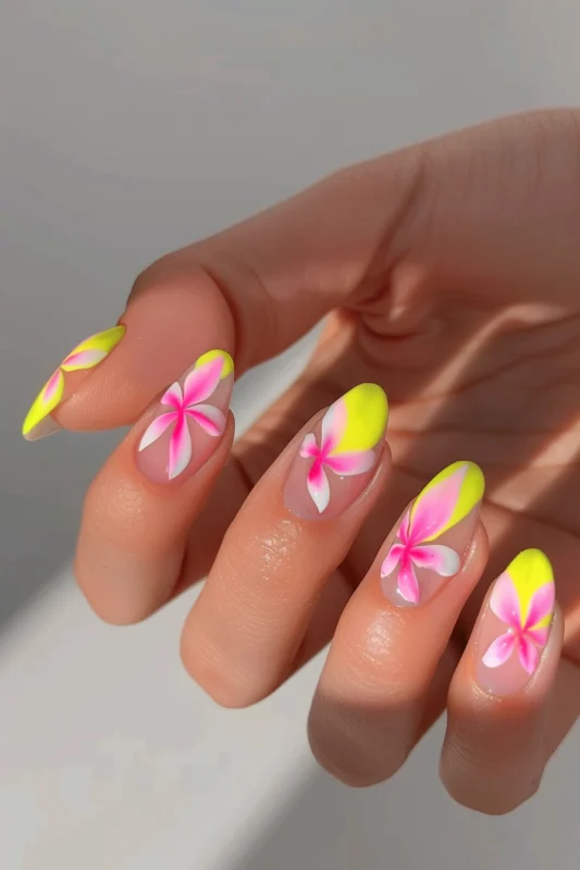 Transparent nails with bright pink flower details and bright yellow tips.