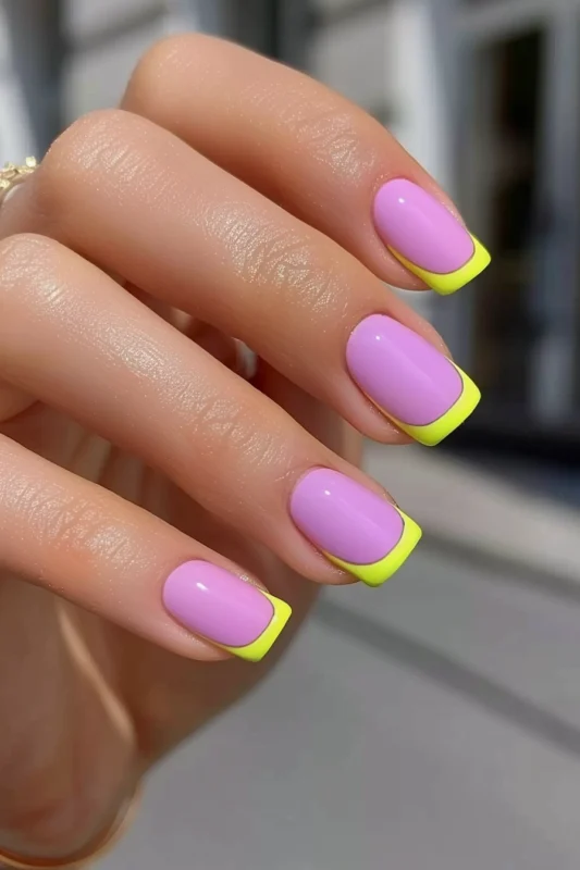 Purple nails with vibrant yellow French tips.