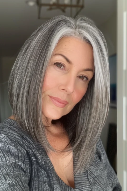 A woman with straight and sleek salt and pepper gray hair.