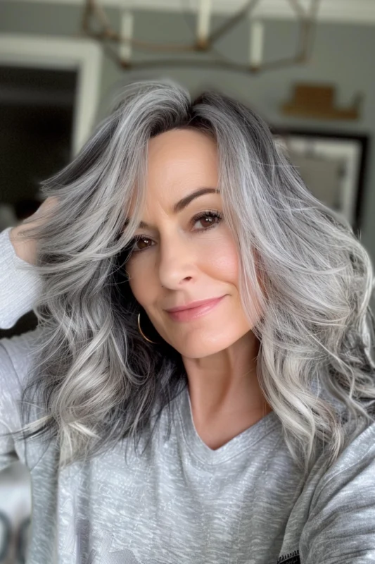 A woman with voluminous salt and pepper curly hair.