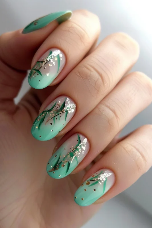 Seafoam green ombre nails with golden streaks and glitter accents.