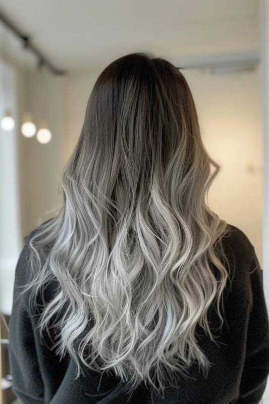 Person with smooth silver ombre hair on a dark base.