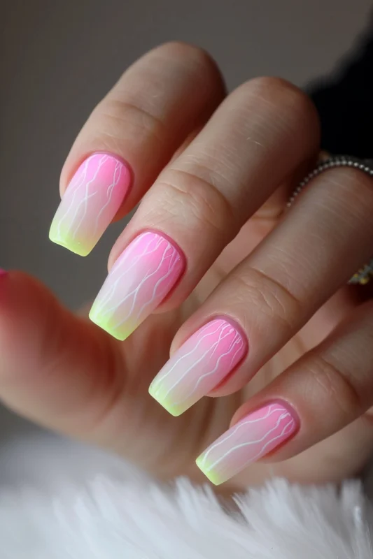 Pink to yellow gradient nails with white wavy lines.