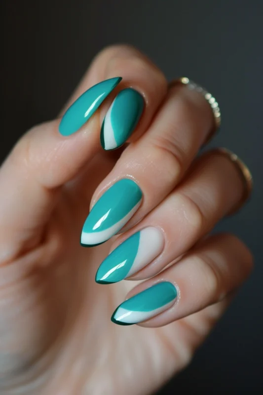 Stiletto nails with a teal to white gradient and dark green tips.