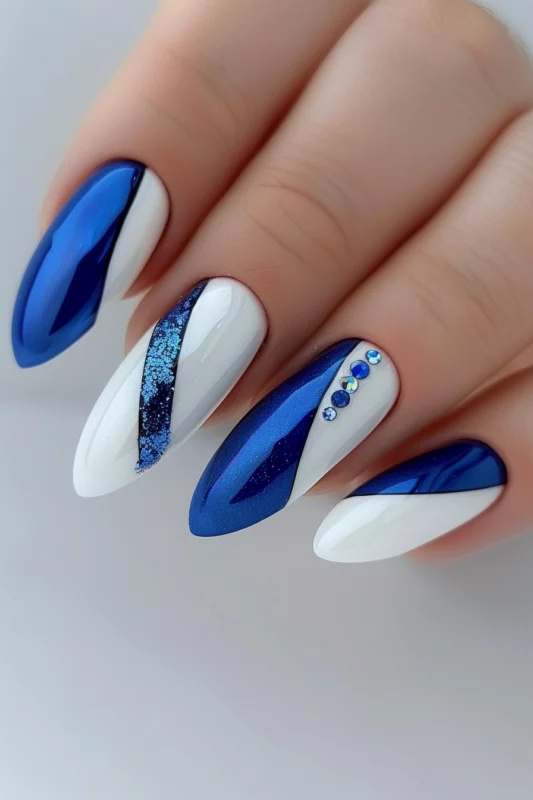 White and blue almond-shaped nails with glitter and rhinestones.