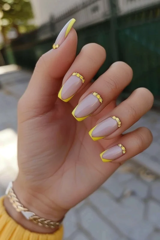 Square nails with dark yellow French tips and golden rhinestone bands.