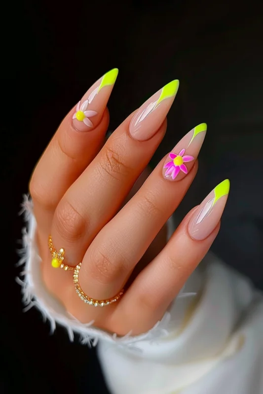 Stiletto nails with neon yellow tips and floral accents