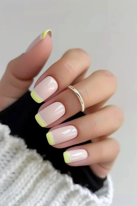 Short square pale pink nails with glossy yellow tips