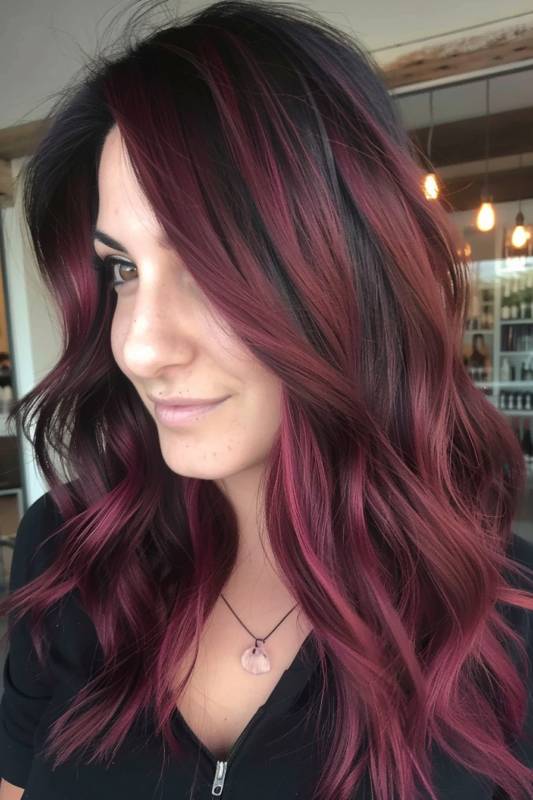 Woman with dark hair and subtle burgundy highlights.