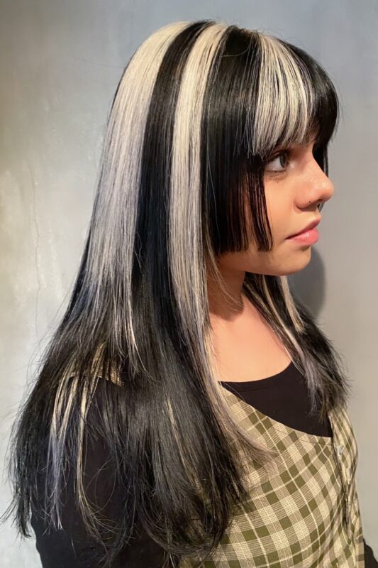 Woman with black and blonde color blocks on her long hair.