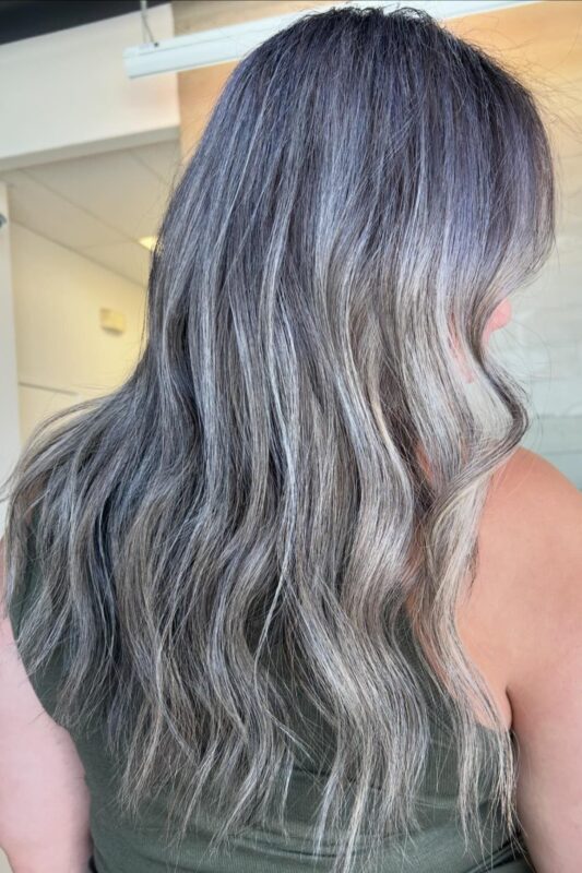 A close-up of blended grey hair color with ash grey and silver tones.