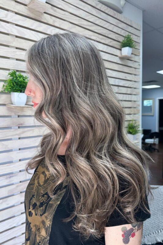 Cool blonde highlights to blend in gray hair on ash brown hair for a sleek look.