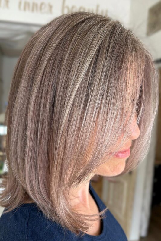 Light brown hair enhanced with warm grey highlights for blending grey.