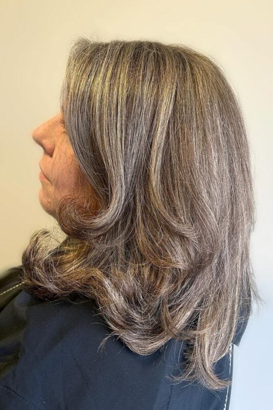 Salt and pepper hair with blonde highlights to blend grays.