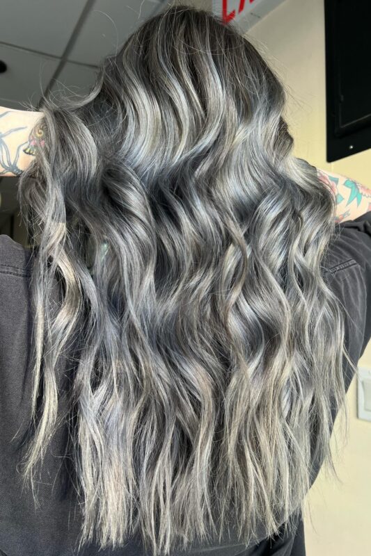 Black hair with golden blonde, ash grey, and white highlights for disguising grays.