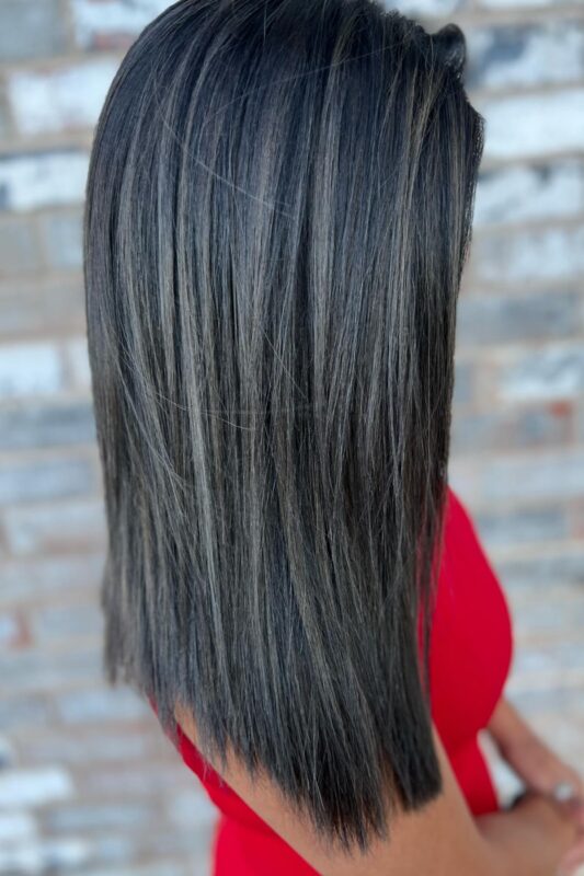 Black hair with silver highlights and dark lowlights for gray blending.