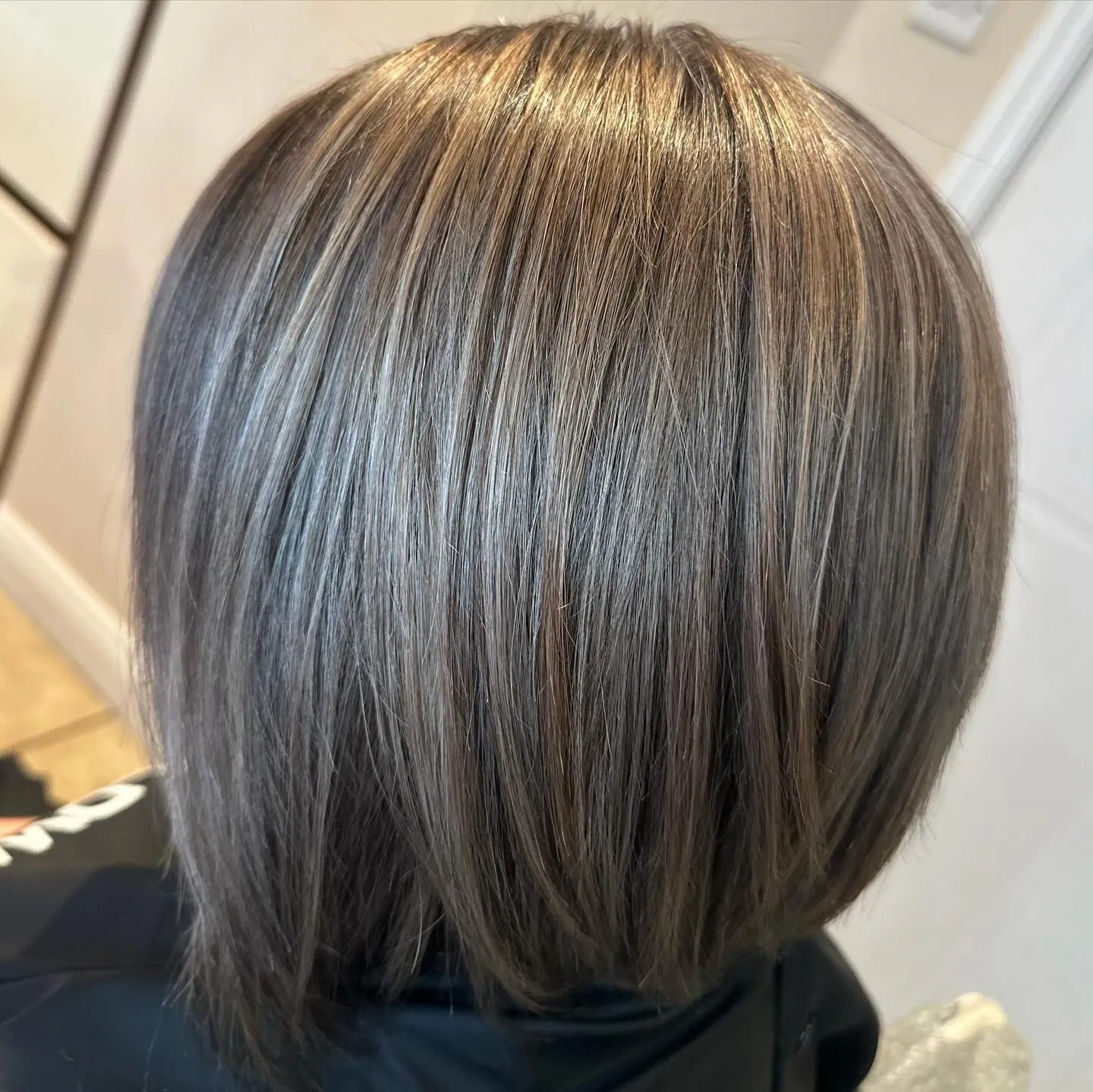 Woman with a natural salt & pepper bob.