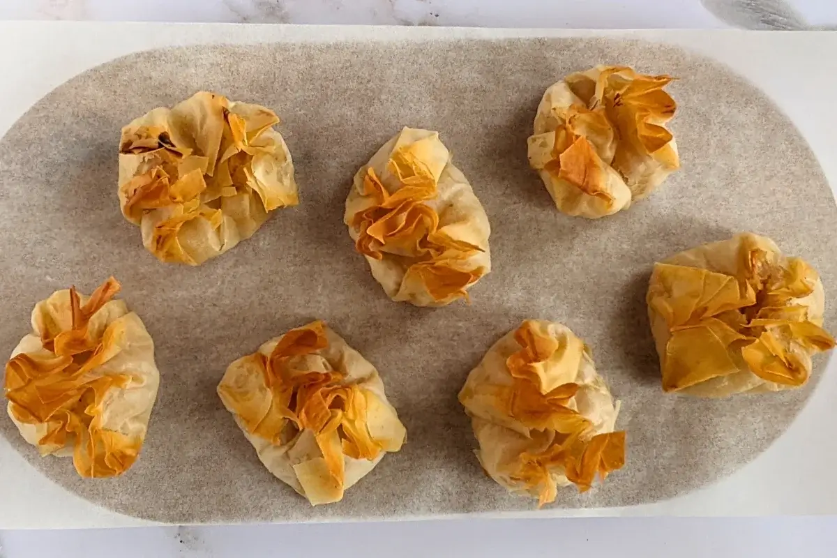 Golden phyllo pastry dessert parcels filled with ricotta and homemade apple sauce, lightly crisped.