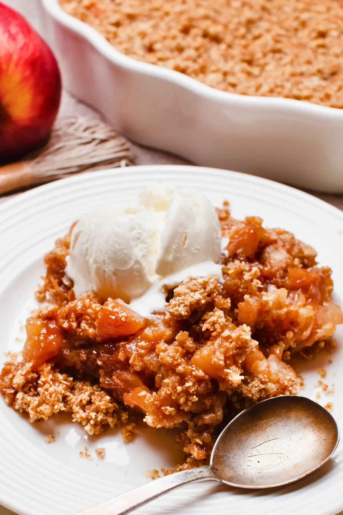Fruit-filled apple crumble with a golden, crumbly topping and chunks of rhubarb and apple at the bottom.
