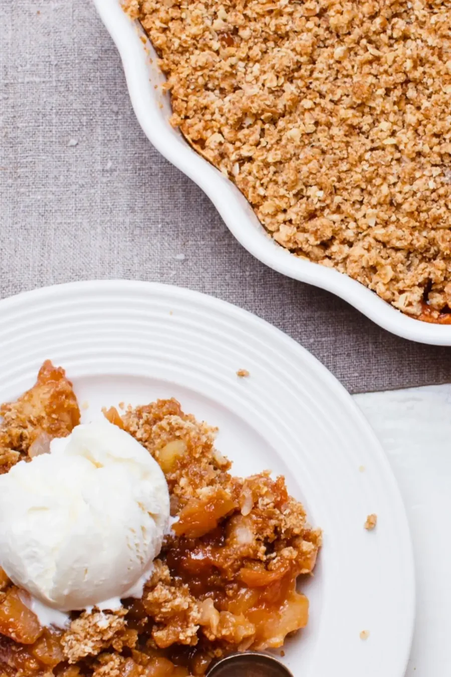 Fruit-filled apple crumble with a golden, crumbly topping and chunks of rhubarb and apple at the bottom.