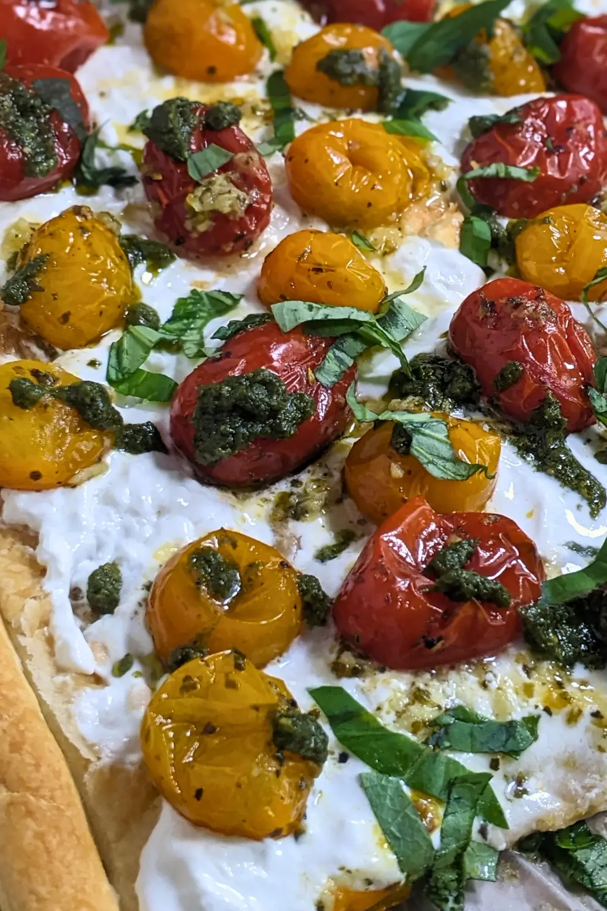 Cherry tomato and burrata appetizer with puff pastry, pesto, and fresh shredded basil.