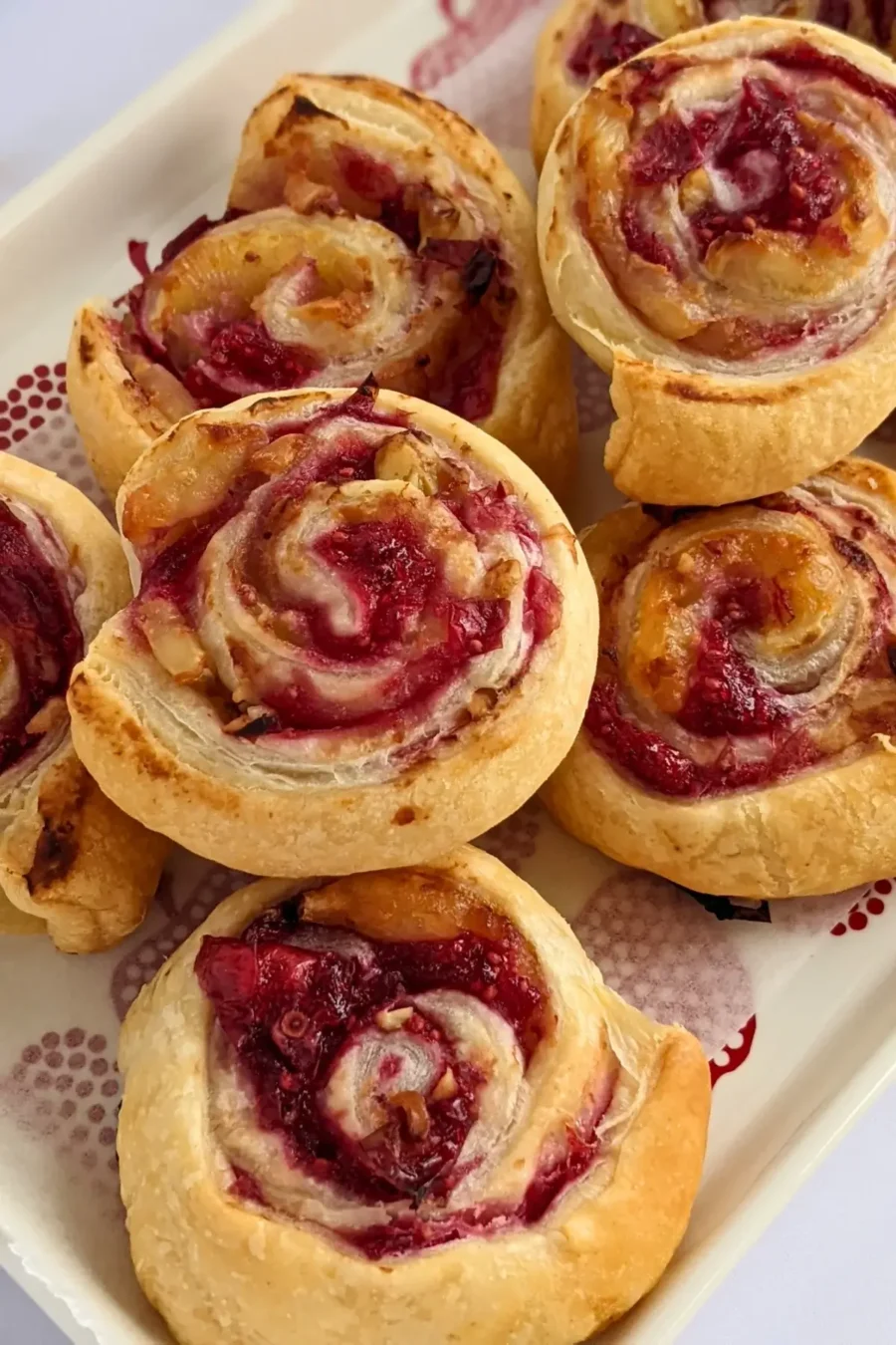Flaky cranberry brie pinwheel bites with puff pastry filled with melted brie and tart homemade cranberry sauce plus walnuts.