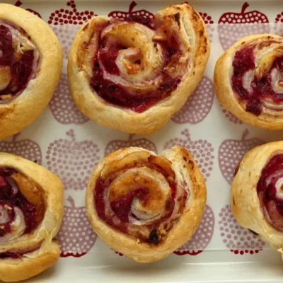 Flaky cranberry brie pinwheel bites with puff pastry filled with melted brie and tart homemade cranberry sauce plus walnuts.