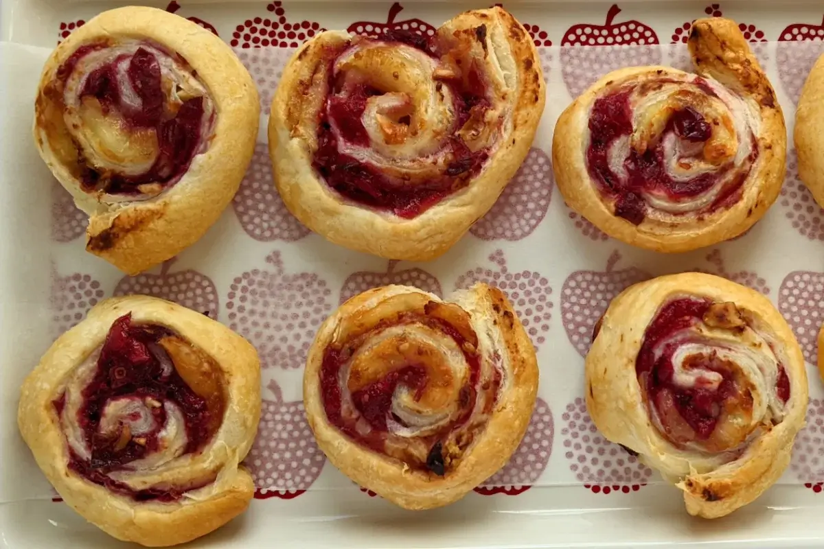 Flaky cranberry brie pinwheel bites with puff pastry filled with melted brie and tart homemade cranberry sauce plus walnuts.