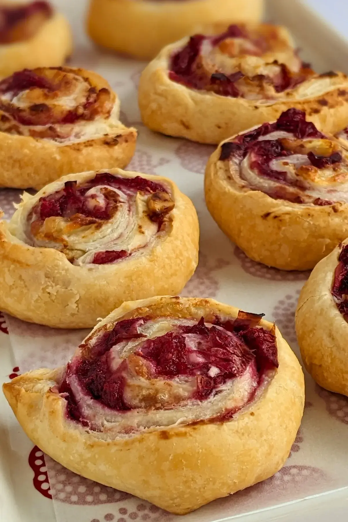 Flaky cranberry brie pinwheel bites with puff pastry filled with melted brie and tart homemade cranberry sauce plus walnuts.