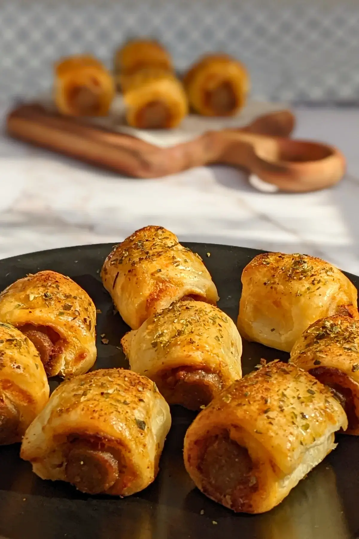Mini Italian sausage rolls with puff pastry - a puff pastry appetizer filled with baked Italian-style sausages, topped with parmesan cheese and a salsa, mustard, and balsamic vinegar sauce.