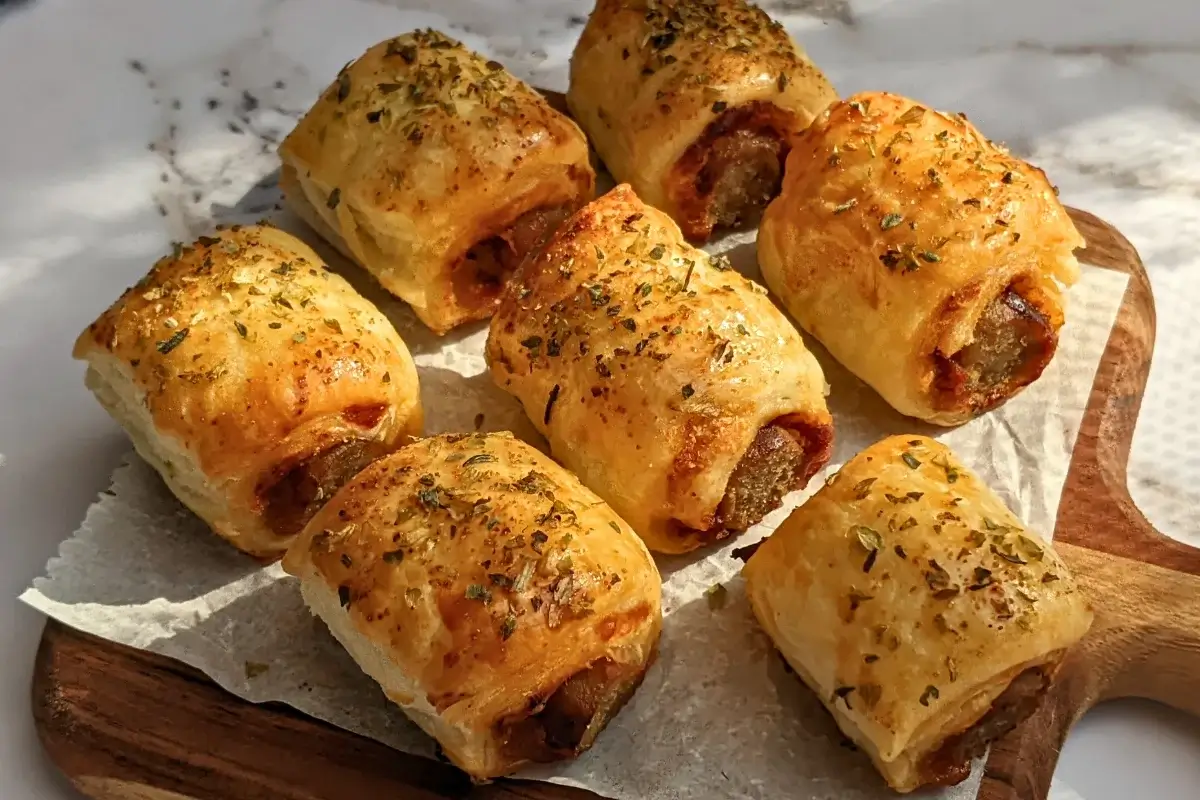 Mini Italian sausage rolls with puff pastry - a puff pastry appetizer filled with baked Italian-style sausages, topped with parmesan cheese and a salsa, mustard, and balsamic vinegar sauce.