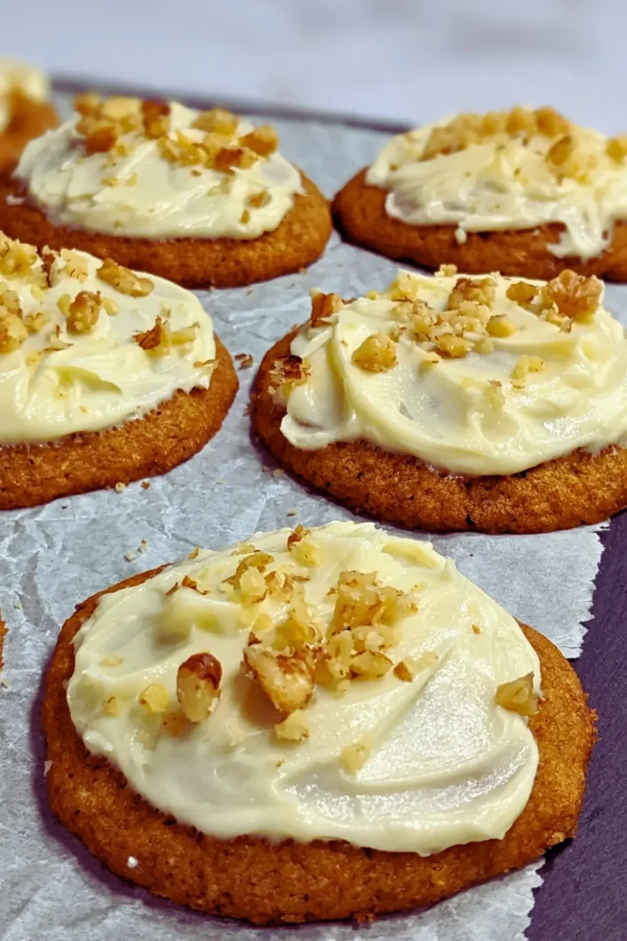 Pumpkin cookies with cream cheese icing made partly with healthier wholemeal flour and coconut sugar, frosted with a cream cheese icing and topped with crushed walnuts for decoration.