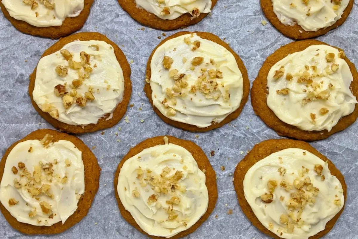 Pumpkin cookies with cream cheese icing made partly with healthier wholemeal flour and coconut sugar, frosted with a cream cheese icing and topped with crushed walnuts for decoration.