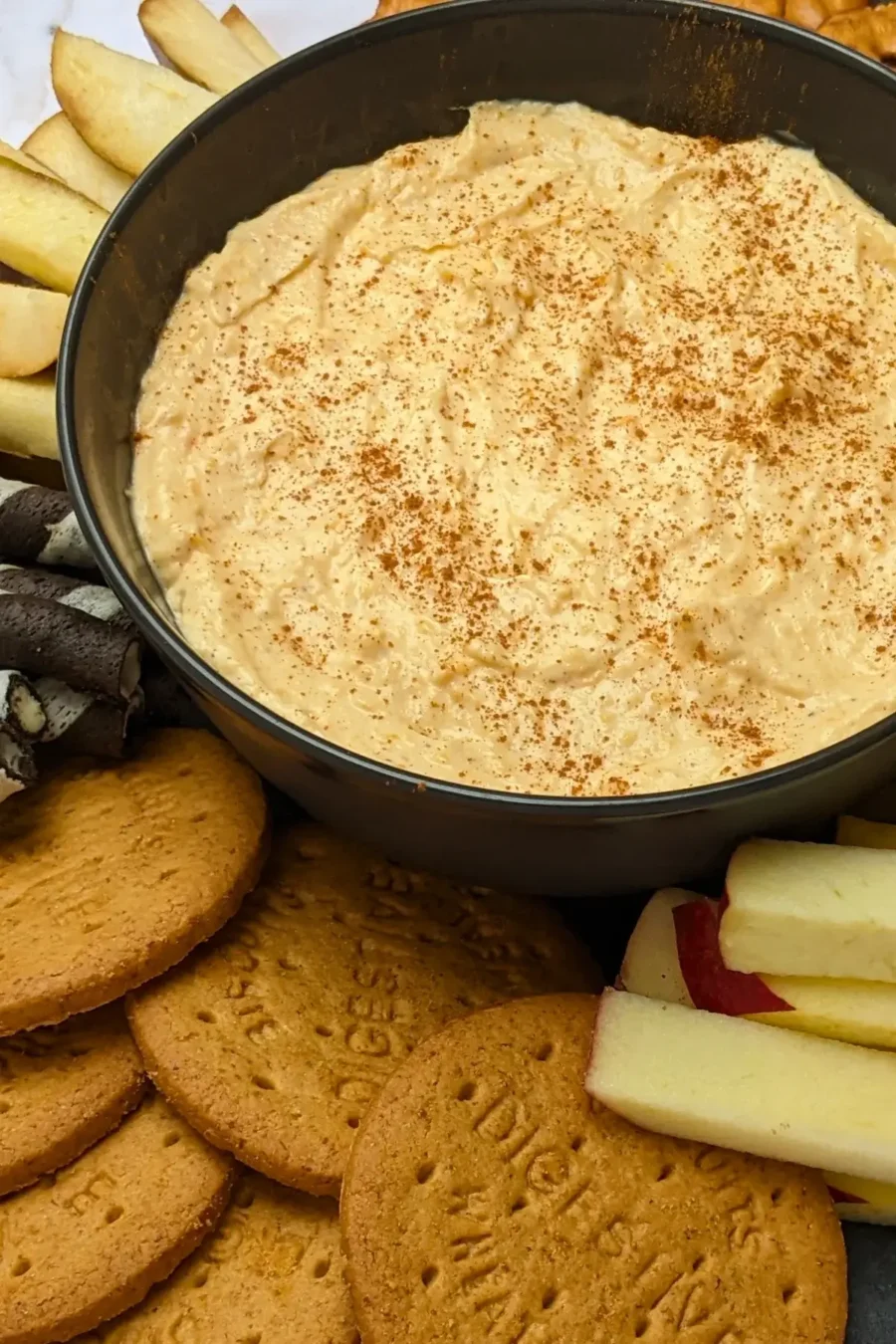Pumpkin dip with cream cheese, cinnamon, pumpkin pie spice and Greek yogurt served with sliced apples and pears, vanilla wafer sticks, biscuits, and pretzels.