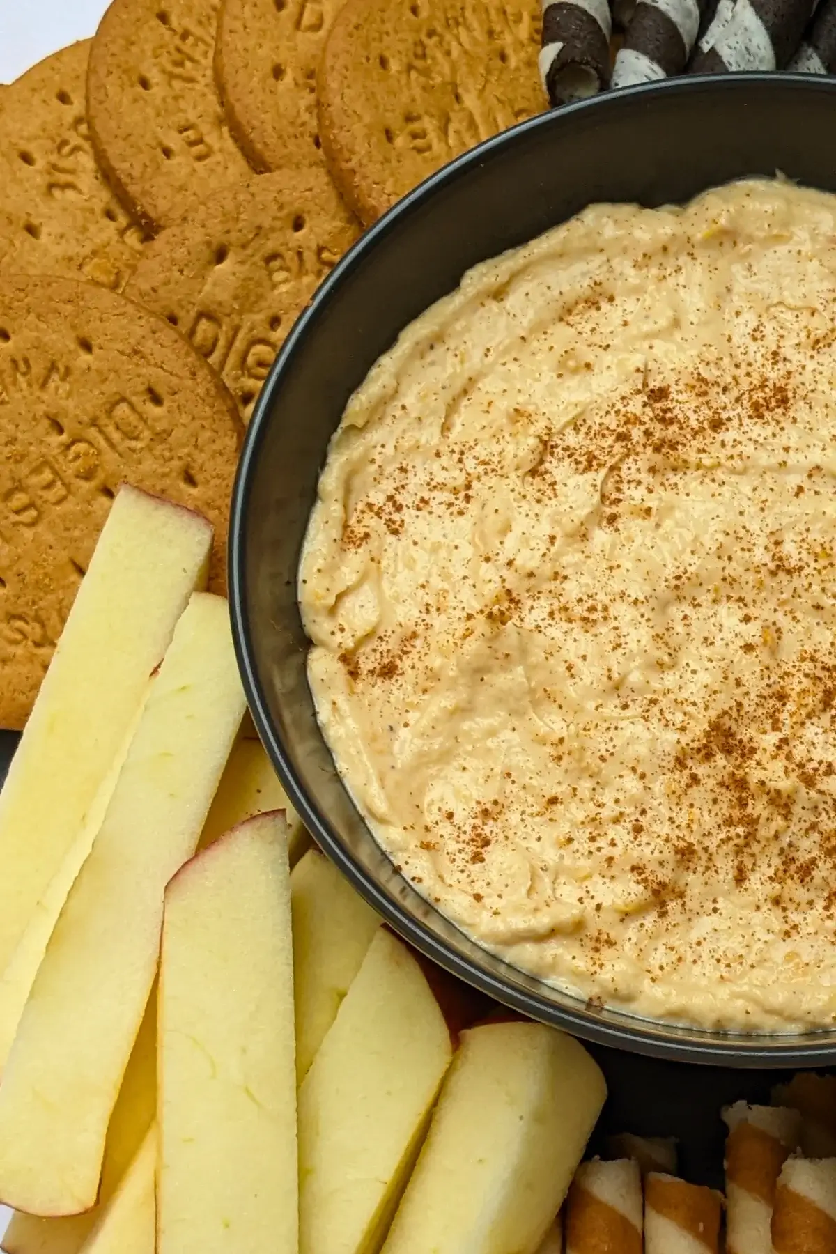 Pumpkin dip with cream cheese, cinnamon, pumpkin pie spice and Greek yogurt served with sliced apples and pears, vanilla wafer sticks, biscuits, and pretzels.