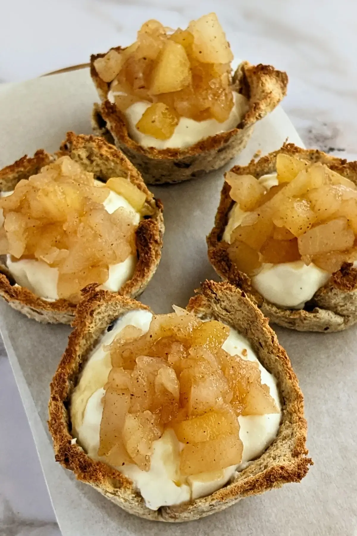Ricotta and homemade apple sauce dessert toast cups - Muffin tin toasted bread cups with creamy ricotta filling and a generous spoonful of spiced homemade apple sauce.